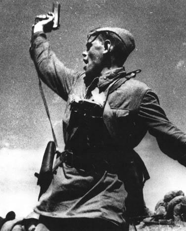 A Soviet junior political officer (Politruk) urges Soviet troops forward against German positions. By RIA Novosti / Alpert / CC-BY-SA 3.0