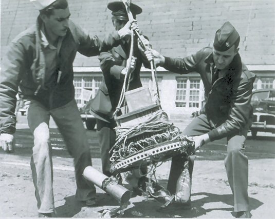 US military personnel carrying the remains of a bomb load Image Source: