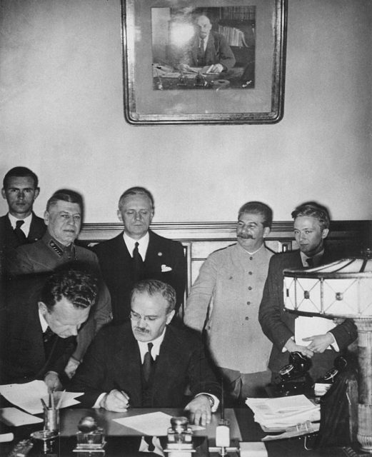 Soviet Foreign Minister Vyacheslav Molotov signs the German-Soviet non-aggression pact in Moscow, August 23, 1939 [Public Domain | Wikipedia]