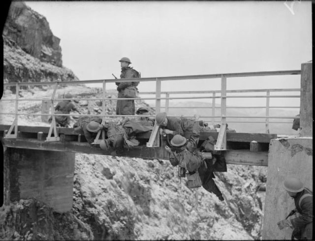 Sailor sappers placing the charges in the bridge over a rapid stream whilst they are training at Hvalfjord, Iceland. © IWM (A 7941)