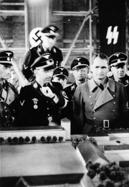 Himmler and Rudolf Hess at Dachau in 1936, viewing a scale model of the camp. Photo Credit.