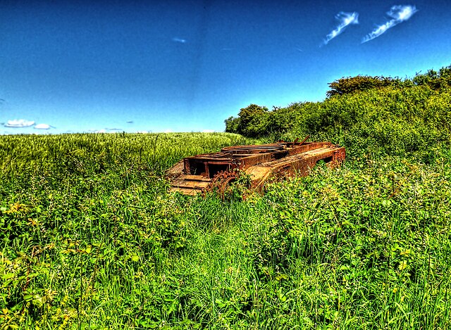 Rusty Churchill M2 tank in a grassy field