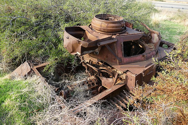 Rusty remains of a PzKpfw IV half-buried in the ground