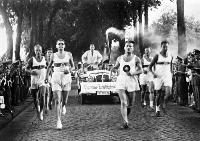 Runners carrying the Olympic Flame. Pgoto Credit.