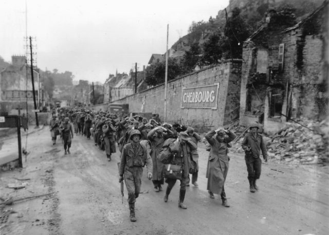 German prisoners being escorted back by American troops Cherbourg, 1944. Image Source: Wikimedia Commons/public domain.