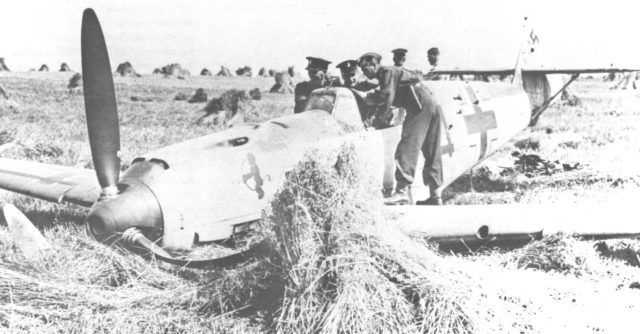 A mix of Army and Air Force personnel mill around the cockpit area of a downed Luftwaffe Bf 109E during the Battle of Britain. Photo credit: Royal Canadian Air Force