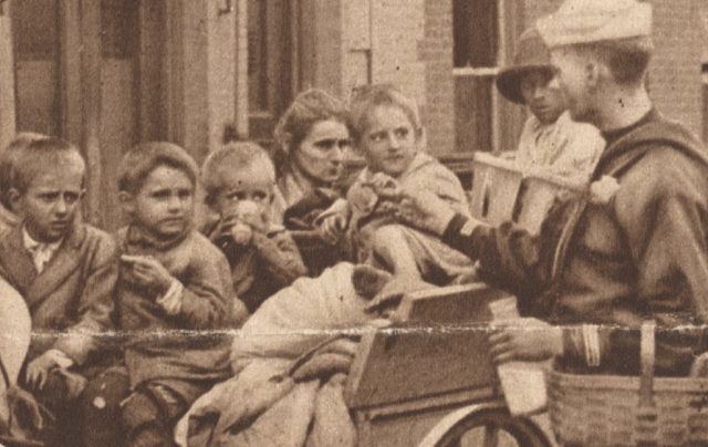 A sailor, or possibly Coast Guardsman (the uniforms were almost identical) hands out food and milk to a homeless mother and her children. Image Source: Library of Congress Archives, by: New York Times, public domain