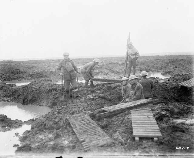 Canadian pioneers laying trench mats over mud to ease movement. Second battle of Passchendaele.