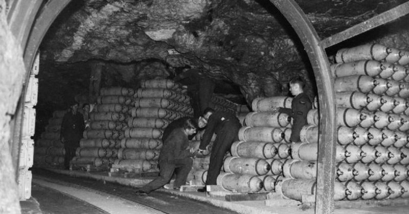 Storemen stack 250-lb MC bombs in one of the tunnels at No. 21 Maintenance Unit at Fauld, near Hanbury, Staffordshire. RAF Fauld, situated in a former gypsum mine, was the main repository of high explosive ordnance in the country. Part of the MU blew up on 27 November 1944, - the World's largest non-nuclear explosion, - and 70 servicemen and civilian workers were killed or declared missing.