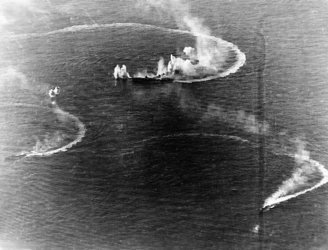 A Japanese aircraft carrier and two destroyers under attack during the Battl elf the Philippine Sea.