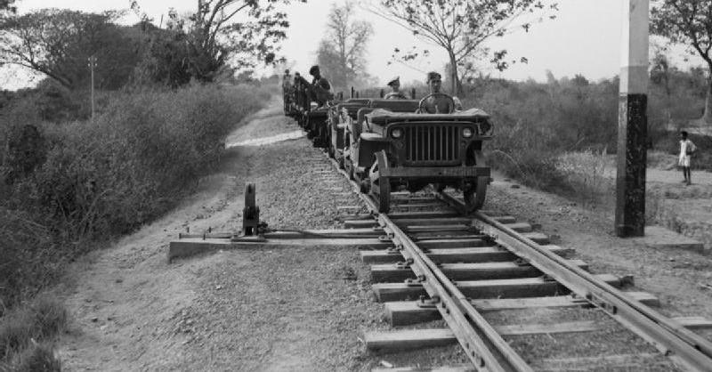Jeeps adapted for running on railway tracks head southwards from Mandalay, Burma, 1945.