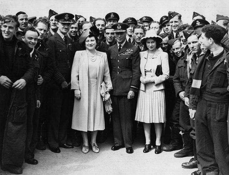 Elizabeth the Queen Mother, King George VI and Princess Elizabeth standing with Royal Air Force airmen