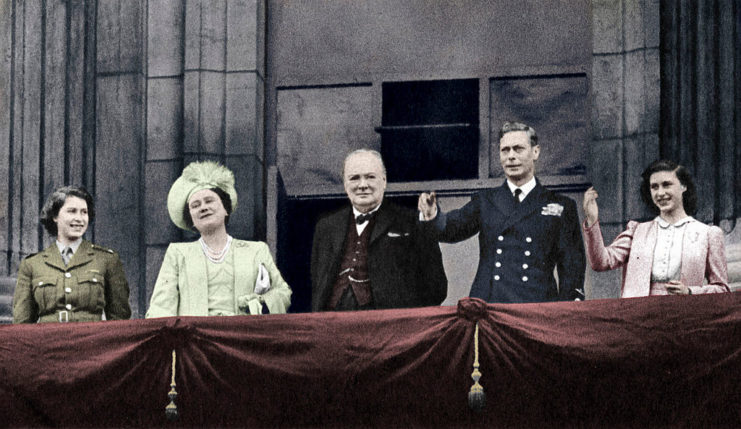 Winston Churchill and the British Royal Family standing on the balcony at Buckingham Palace