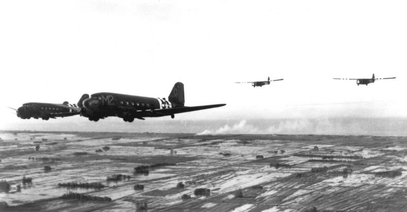 Troop carrier Douglas C-47s tow Waco CG-4A gliders during the invasion of France in June 1944. 