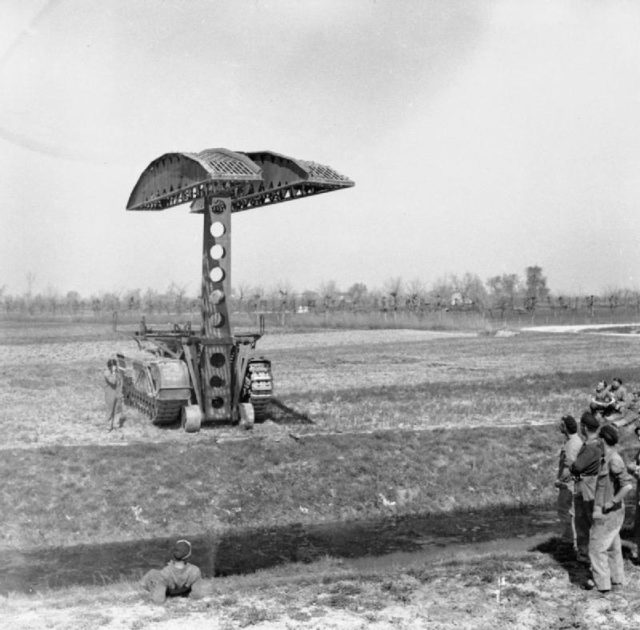 A Churchill bridgelayer of 51st Royal Tank Regiment in action during a demonstration in the Mezzano area, 30 March 1945. Photo Credit.