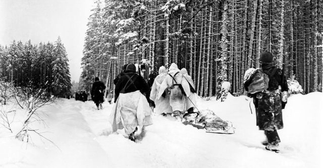 Battle of the bulge – American troops drag a heavily loaded ammunition sled through the snow, as they move for an attack on Herresbach, Belgium.