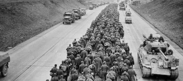 Surrendered Germans troops under guard by US soldiers in 1945.