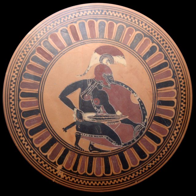 An ancient Greek warrior depicted with sword and shield.