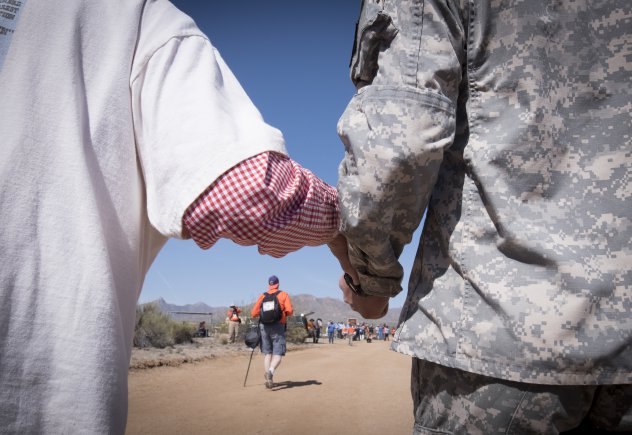 Reserve Officer Training Corps cadet Noah Cruse, a freshman studying industrial engineering at New Mexico State University (right) steadies retired U.S. Army Col. Ben Skardon, 98, as they walk in the 27th annual Bataan Memorial Death March, March 20, 2016. Skardon is the only Bataan survivor who walks in the march. Credit: U.S. Army photo by Staff Sgt. Ken Scar.