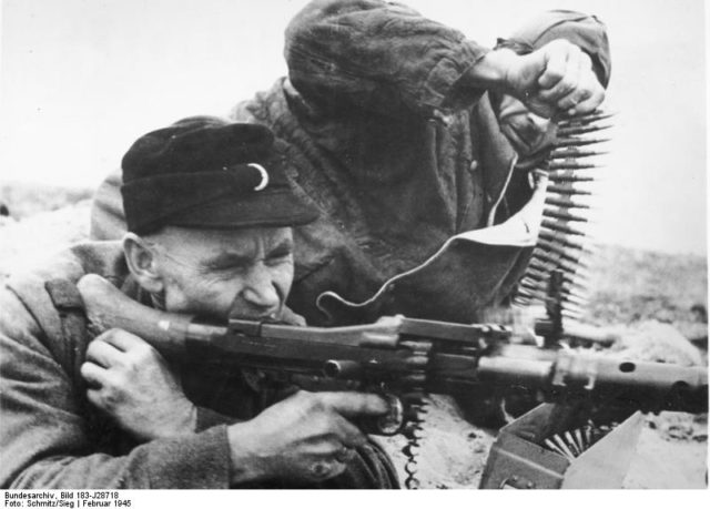German Volkssturm militia fighters fire their MG-34 machine gun at the Russians in one of the last, desperate battles in Silesia (now in Poland) Feb 1945. By Bundesarchiv – CC BY-SA 3.0 de