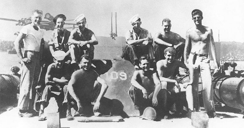 Lieutenant John F. Kennedy, USNR, (standing at right) with other crewmen on board PT-109, 1943.
