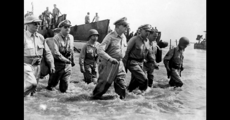 Gen. Douglas MacArthur wades ashore during initial landings at Leyte, Philippine Islands.