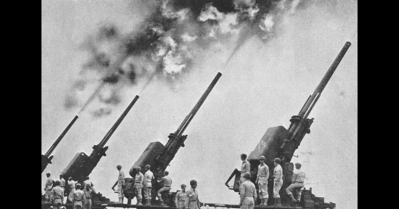 Antiaircraft guns firing, WWII. <a href=https://www.flickr.com/photos/rdecom/5162136946>Photo Credit</a>