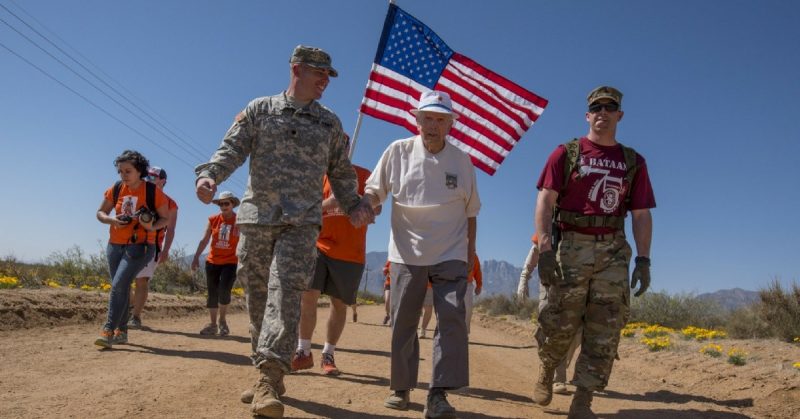 Retired U.S. Army Col. Ben Skardon, 99, a survivor of the Bataan Death March, walks in the annual Bataan Memorial Death March at White Sands Missile Range, accompanied by green-to-gold New Mexico State University Army Reserve Officers' Training Corps cadet Ryan Bradley (left) and Spc. Michael Cole of the McAfee Army Health Clinic - both Army medics - March 19, 2017. This was the tenth time Skardon walked a distance of eight and a half miles in the march - and he is the only survivor who walks in it. (U.S. Army Reserve photo by Staff Sgt. Ken Scar)