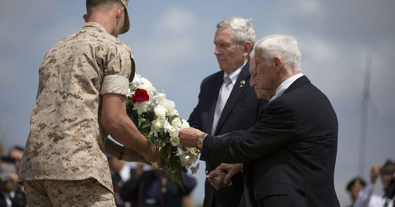 Retired Lt. Gen. Lawrence F. Snowden, center, places a flower wreath at the base of the Reunion of Honor monument during the 70th Anniversary Reunion of Honor of the Battle of Iwo Jima.