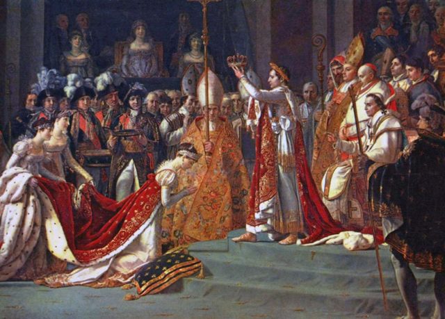 Joséphine kneels before Napoleon during his coronation at Notre Dame.