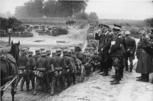 German soldiers marching into Poland in September 1939 watched by Hitler.