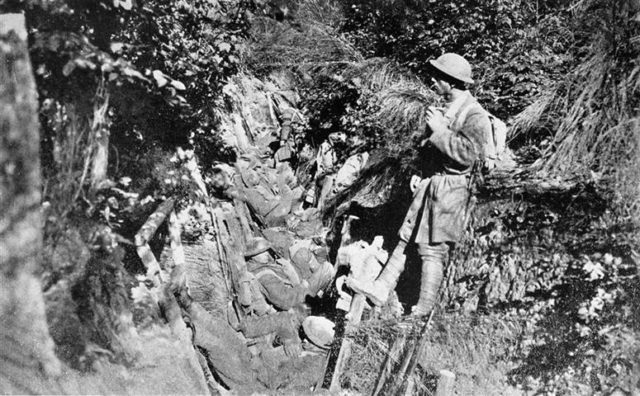 American soldiers rest in trench in Argonne Forest .