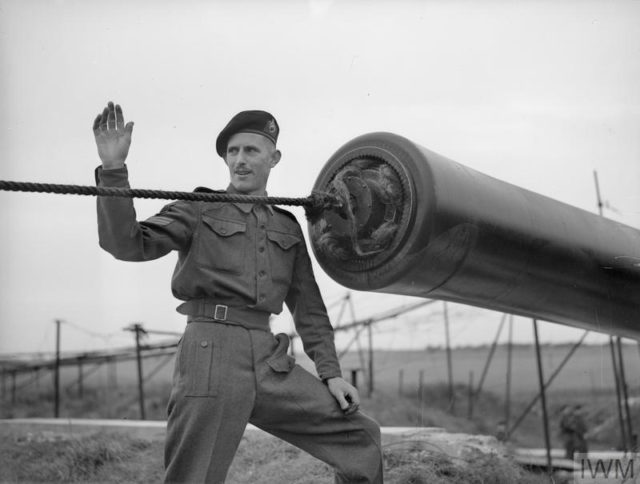 Sergeant of the gun crew at the muzzle of ‘Winnie’ during sponging out after bombardment. Copyright: © IWM. Photo Credit