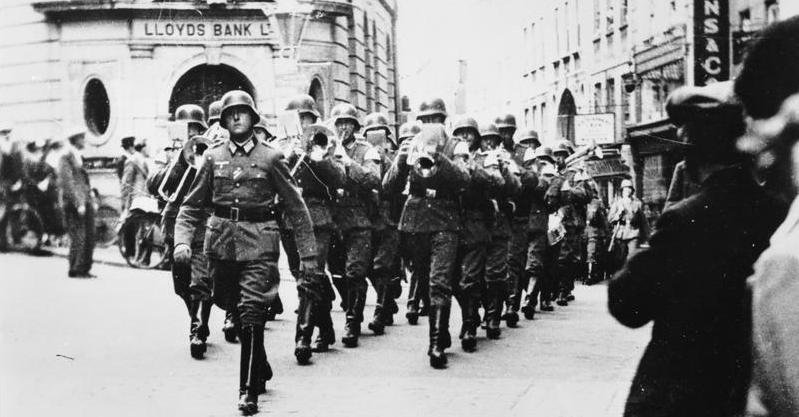 German military band marching past Lloyds Bank on The Pollet, St Peter Port at Guernsey. Copyright: © IWM.  <a href=http://www.iwm.org.uk/collections/item/object/205088496>Original Source</a>