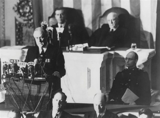 Roosevelt delivers the “Day of Infamy” speech to a joint session of Congress on December 8, 1941. To the right, in uniform, is Roosevelt’s son James, who escorted his father to the Capitol. Seated in the back are Vice President Henry Wallace and Speaker Sam Rayburn.