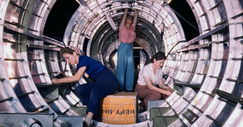 Women workers install fixtures and assemblies to a tail fuselage section of a B-17 bomber at the Douglas Aircraft Company.