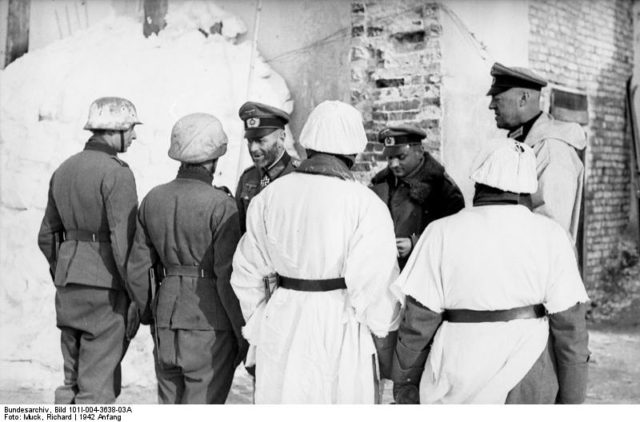 General Scherer (left, with cap) presenting awards to soldiers, 1942, Cholm, Soviet Union. By Bundesarchiv – CC BY-SA 3.0 de
