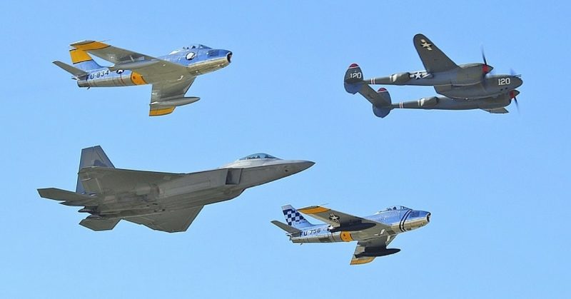 US built aircraft fighters representing different eras; a World War II P-38 Lightning, a pair of F-86 Sabres from early jet age and a modern F-22 Raptor.