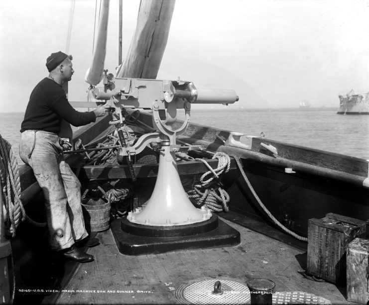 U.S.S. Vixen, Maxim machine gun and gunner Smith. The gun appears to be a Maxim-Nordenfelt 37-mm 1-pounder autocannon, known to the British as a “pom-pom”.