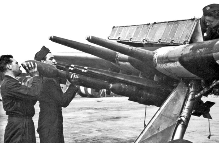 3 inch, 60 pounder SAP, Rocket Projectiles being loaded onto the launch rails of an RAF Hawker Typhoon, circa 1944. A pair of 20mm cannon barrels can be seen above the launch rails.