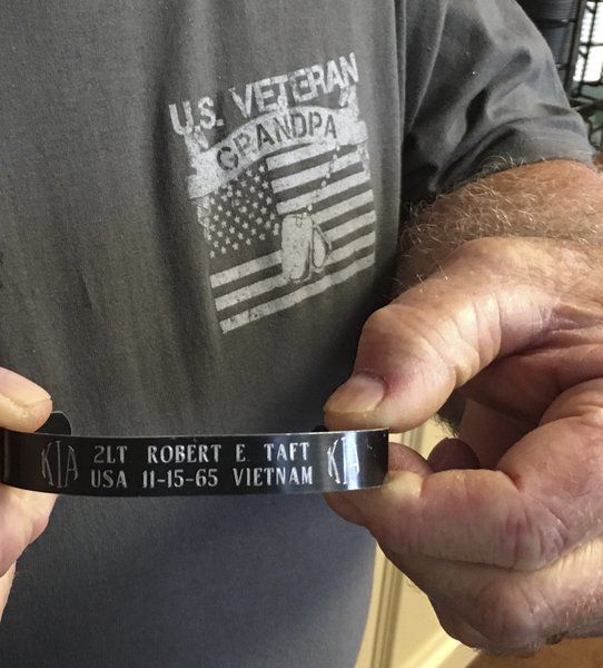 Photo: Karen Murphy/Special to the Times-Enterprise. Retired Master Sgt. Robert Hazen, of Clarksville, Tennessee, reverently displays a bracelet honoring his fallen friend and platoon leader, 2nd Lt. Robert Taft, of Highland Park, Illinois.