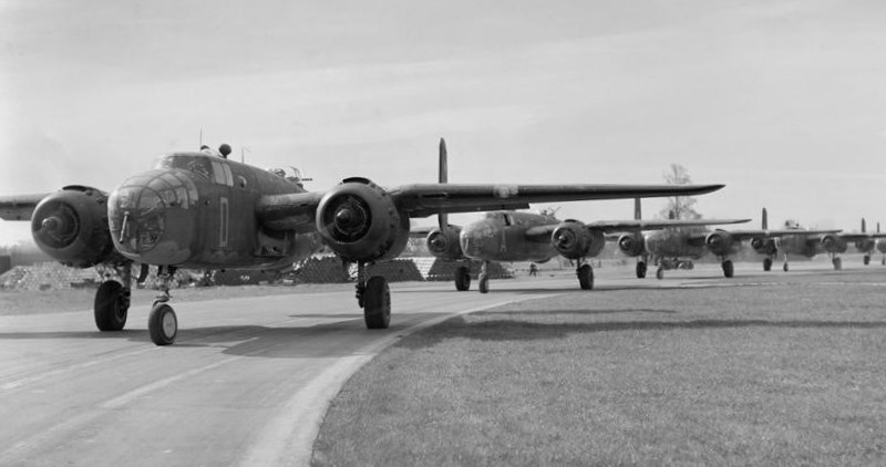 North American Mitchell Mark IIs of No. 98 Squadron RAF taxying along the perimeter track at Dunsfold, Surrey, for a morning raid on targets in northern France. Photo Credit