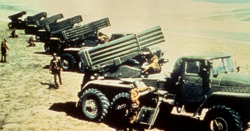 A right side view of six Soviet 122mm BM-21 multiple rocket launcher systems. The BM-21 consists of a Ural-375D truck chassis with a 40-round rocket launcher mounted on the rear of the hull. 