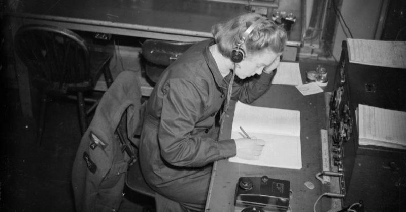 A WAAF wireless operator at work, receiving a message in morse code.