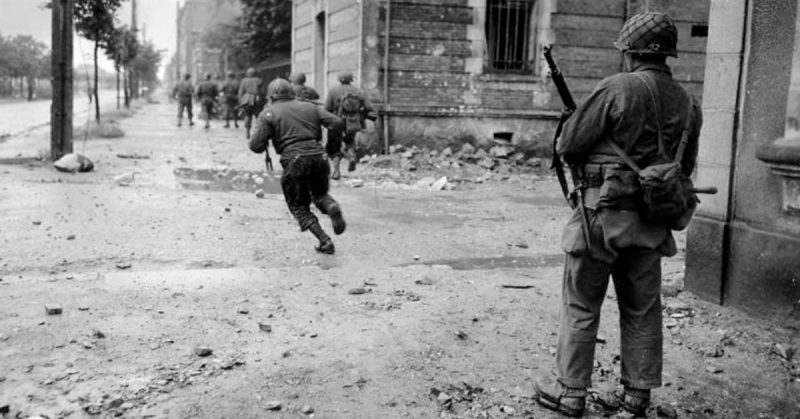 American troops advance forward as they clear the streets of Cherbourg. 