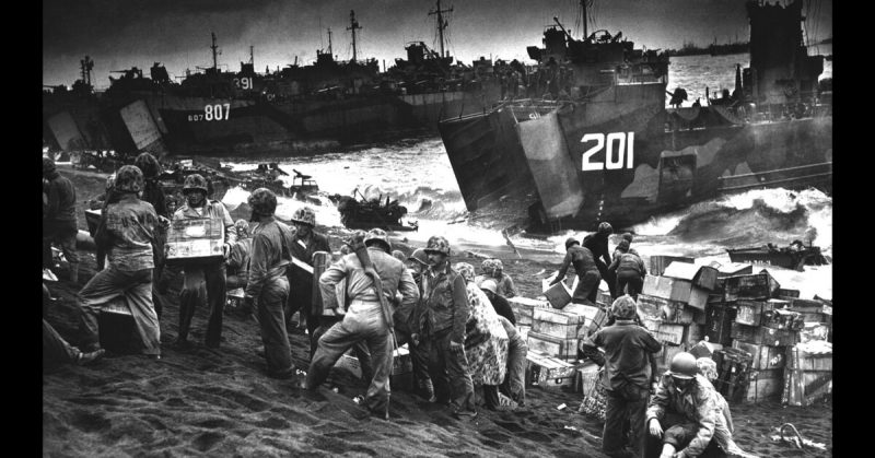 Marines unloading supplies from the open bow of a Navy LST. 