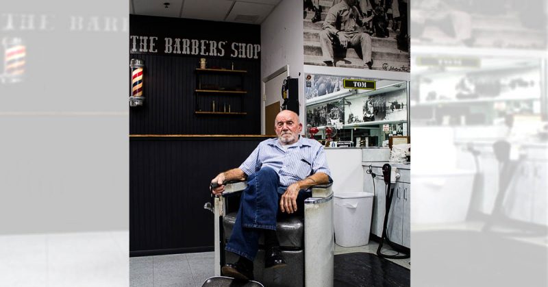 Tom Sakezles, a WWII veteran and owner of The Barbers’ Shop in Tampa sits in the chair where he used to cut hair. Photo by James Judge