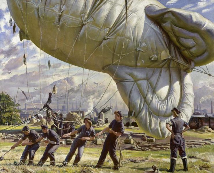 A barrage balloon being hoisted into position by WAAF women in blue overalls.