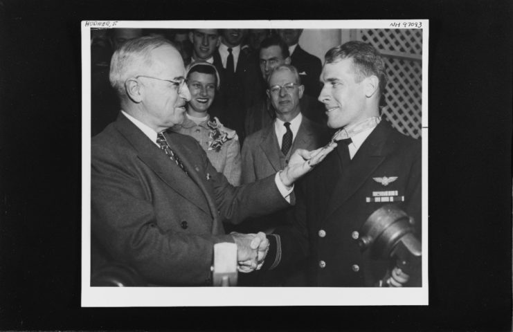 Receives congratulations from President Harry S. Truman, after he was presented with the Medal of Honor in ceremonies at the White House, Washington, D.C. Photograph is dated 13 April 1951. Official U.S. Navy Photograph, from the collections of the Naval History and Heritage Command.