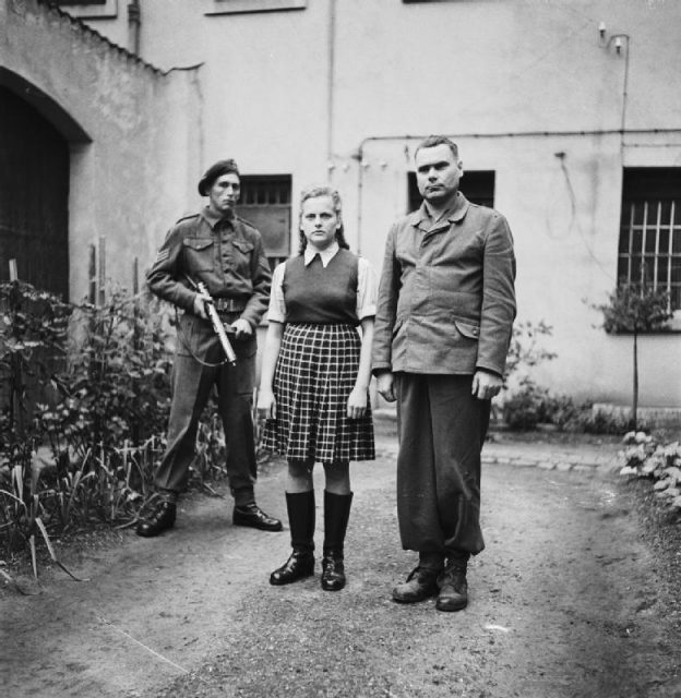 The Liberation of Bergen-Belsen Concentration Camp 1945- Portraits of Belsen Guards at Celle Awaiting Trial, August 1945 Irma Grese standing in the courtyard of the Prisoner of War cage at Celle with Josef Kramer. Both were convicted of war crimes and sentenced to death.